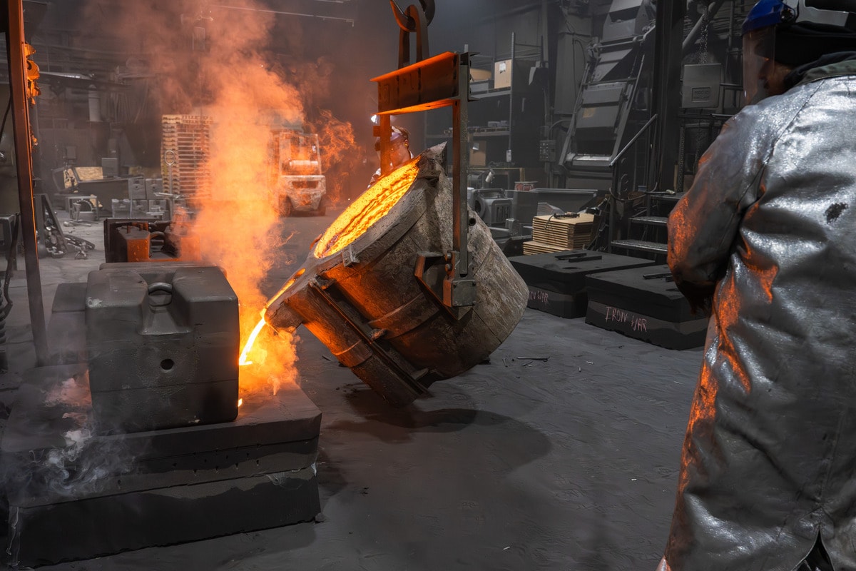 Foundry worker inspecting a metal casting for quality control